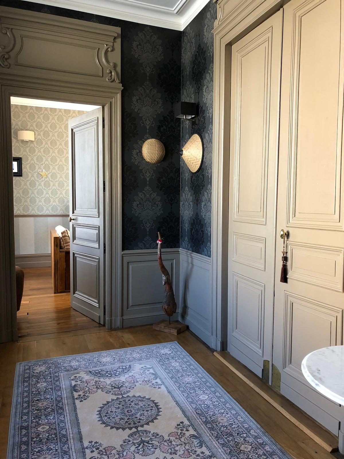 A hallway in the house, wallpaper and rug
