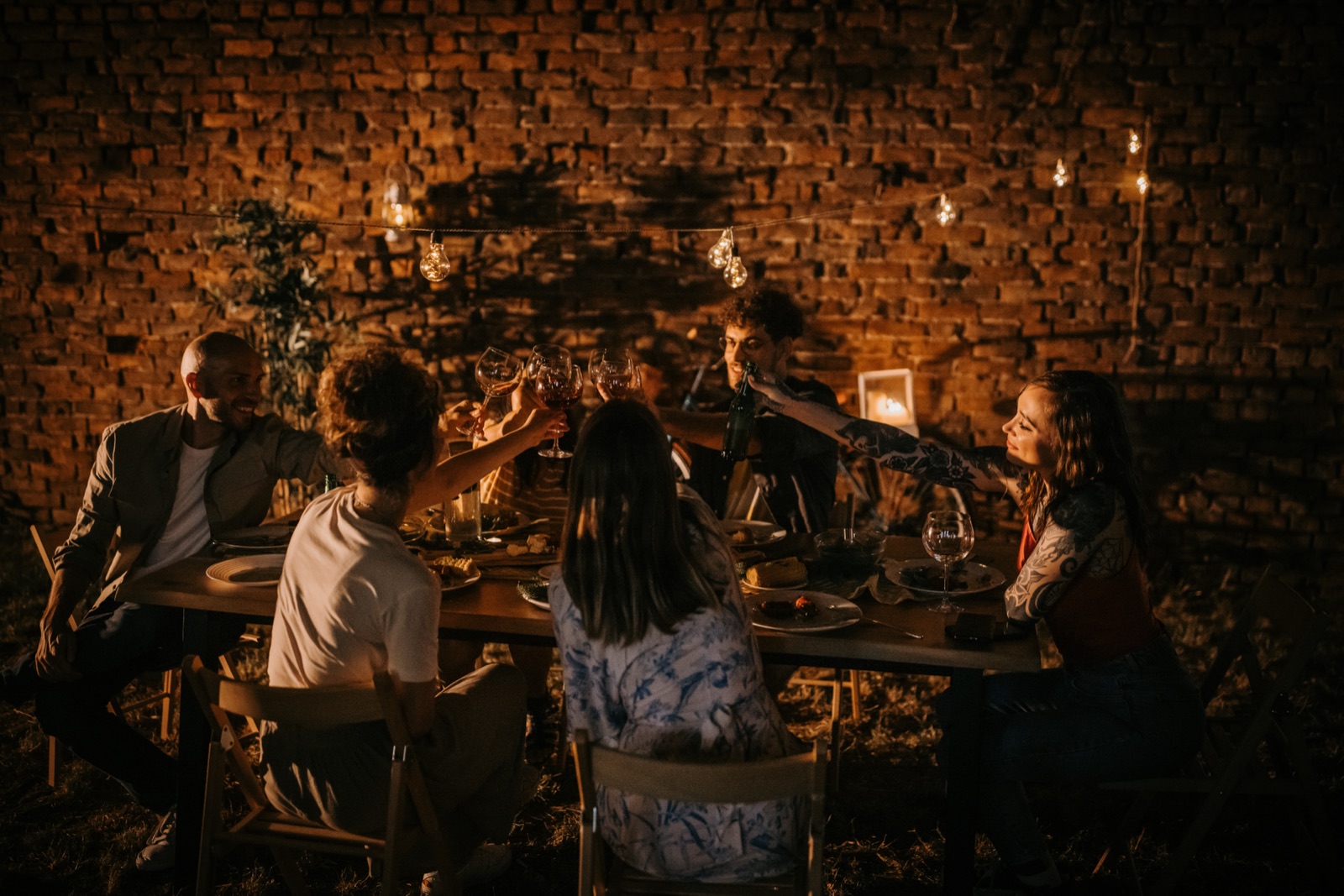 An evening dinner under string lights, in the courtyard